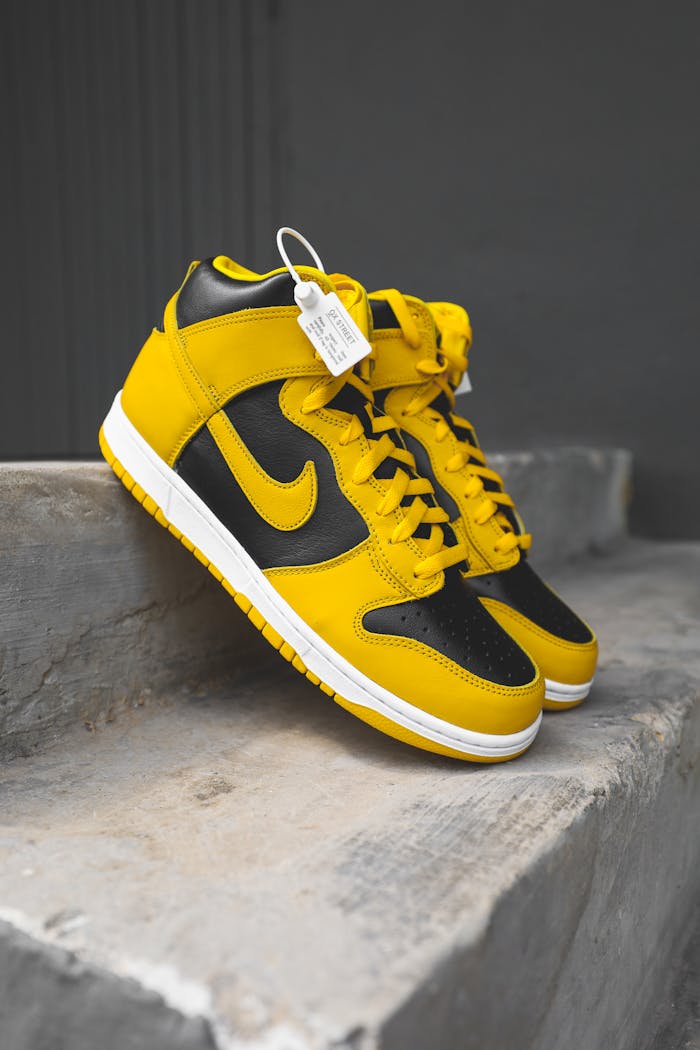 Yellow and black high-top sneakers with a visible tag, photographed on concrete steps.